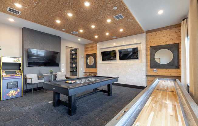 A room with a pool table and a foosball table.