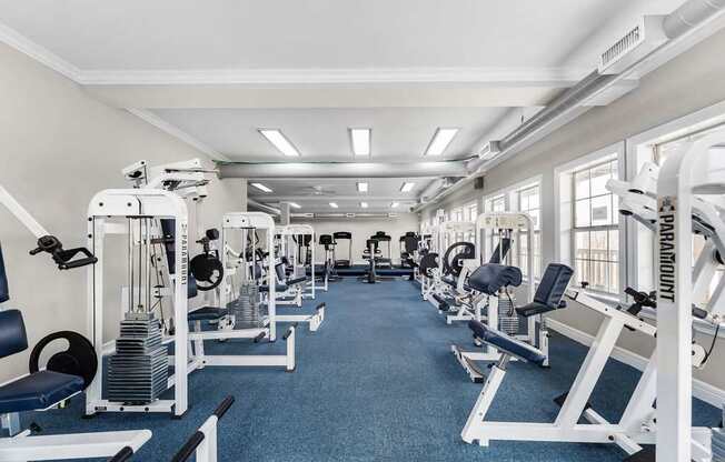 A gym with a variety of equipment including weight machines and benches.