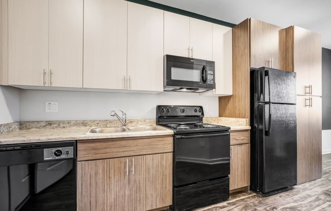 Apartments for Rent Phoenix - Open-Concept Kitchen with Wood Flooring, Black Appliances, and Brown Cabinetry