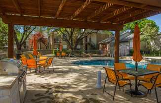 Pool area with grilling station at Chisholm Place Apartments in Plano, TX