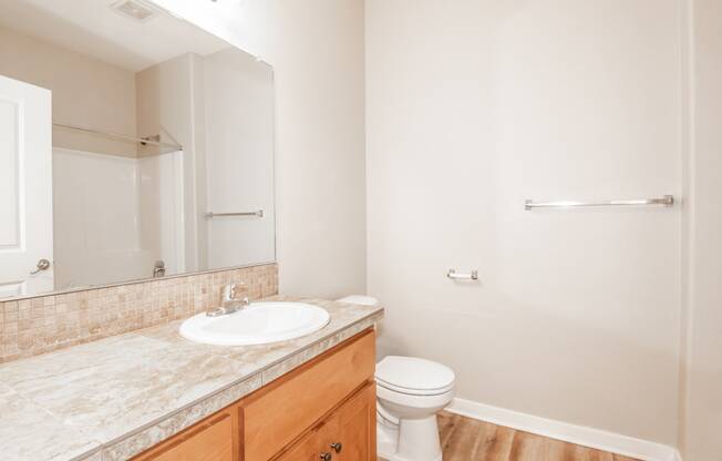 an empty bathroom with a sink toilet and mirror