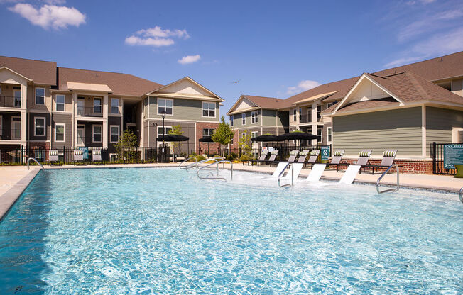 a swimming pool in front of a row of apartment buildings