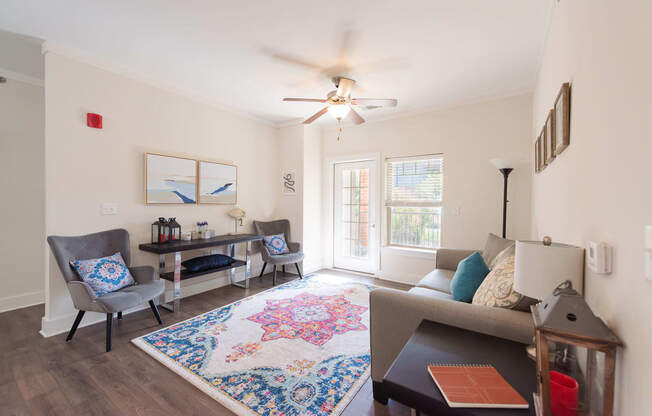 a living room with a ceiling fan and a rug