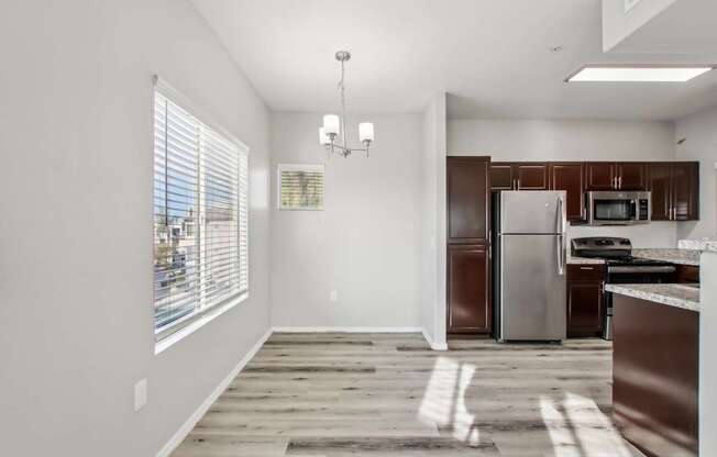 A kitchen with a refrigerator, microwave, and oven.