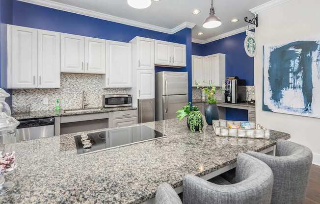 A kitchen with granite countertops and white cabinets.