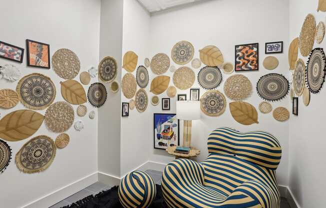 A chair with a black and gold striped cover sits in front of a wall with circular and leaf shaped decorations.