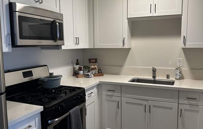 a kitchen with white cabinets and stainless steel appliances