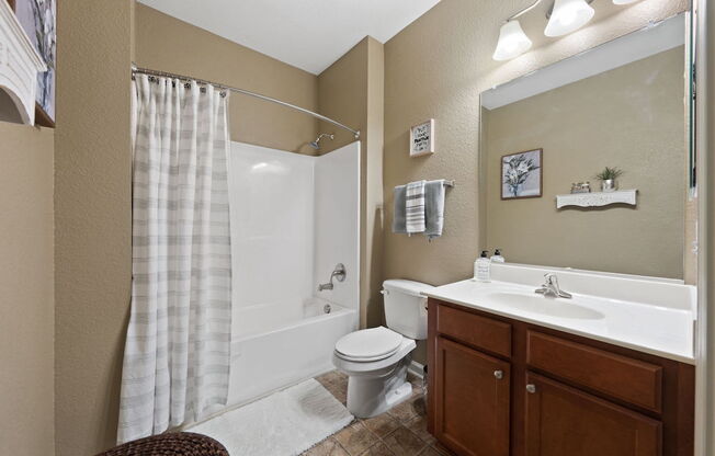 spacious bathroom with tub/shower, and sink vanity with a large mirror and light kit