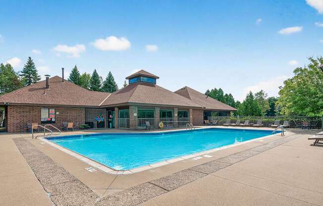 A large outdoor swimming pool with a building in the background.