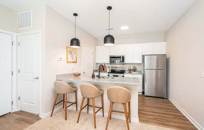 A kitchen with a bar and stools.