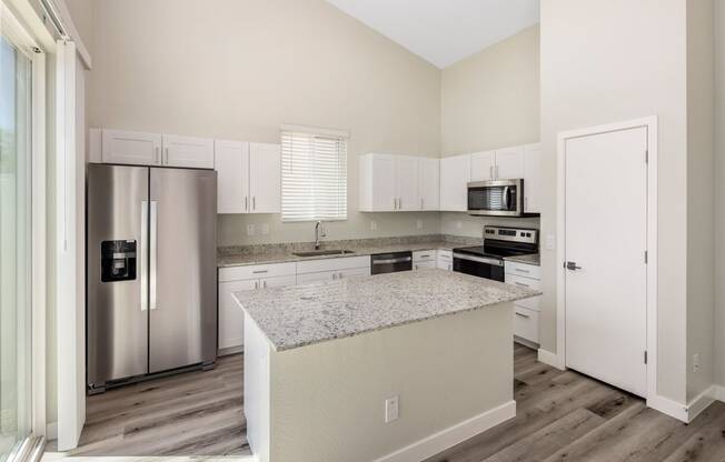 a kitchen with white cabinets and a granite counter top