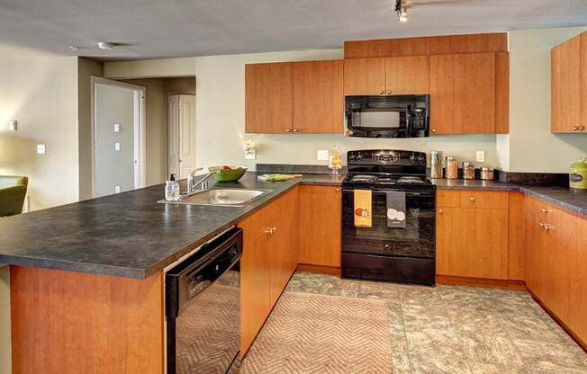 A kitchen with wooden cabinets and a black stove top oven.