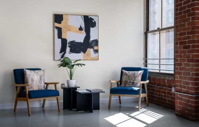 two chairs and a table in a room with a brick wall