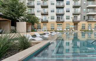A large swimming pool in front of apartment buildings.