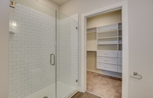a white tiled bathroom with a shower and a closet at The Augustan, Augusta, Georgia