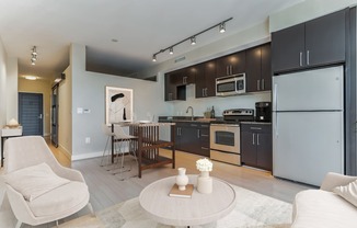 a kitchen and living room with a refrigerator and a table