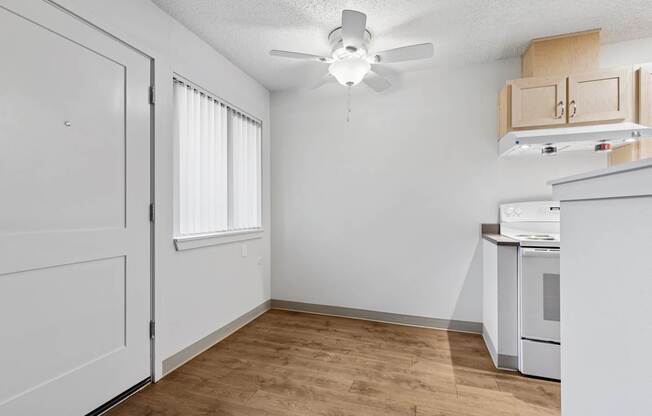 A kitchen area with a white oven and wooden flooring.