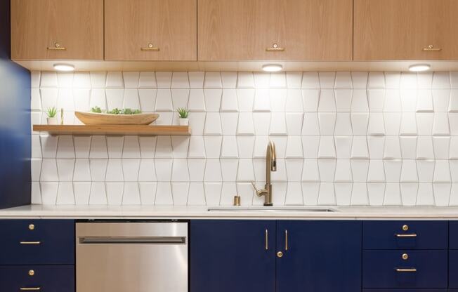 a kitchen with white tiles and navy cabinets