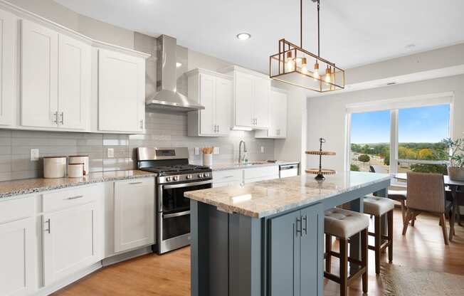a kitchen with a large island and a stove and a window