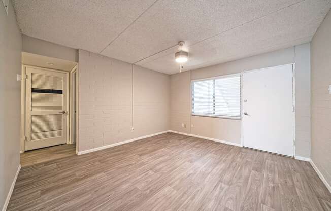 an empty living room with wood flooring and a white door