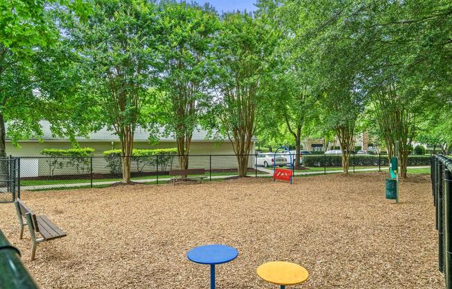 a playground with benches and trees in a park