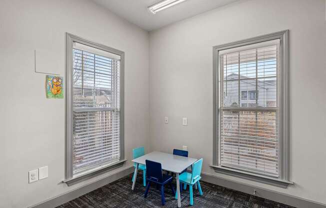 A room with a table and chairs by the window.
