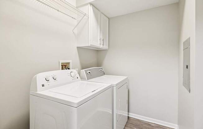 A white washing machine and dryer in a small laundry room.