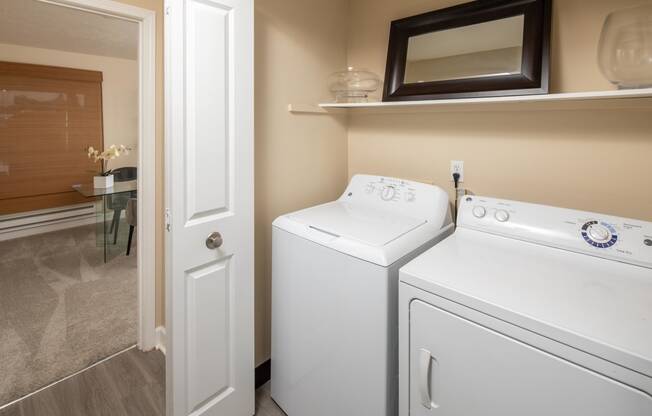 a white washer and dryer in a laundry room with a door to a