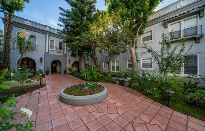 A courtyard with a circular flower bed in the middle.