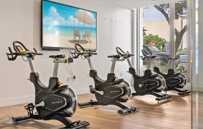 a gym with exercise bikes in front of a window