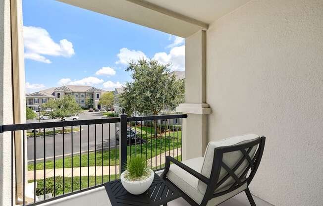 A balcony with a chair and a potted plant.