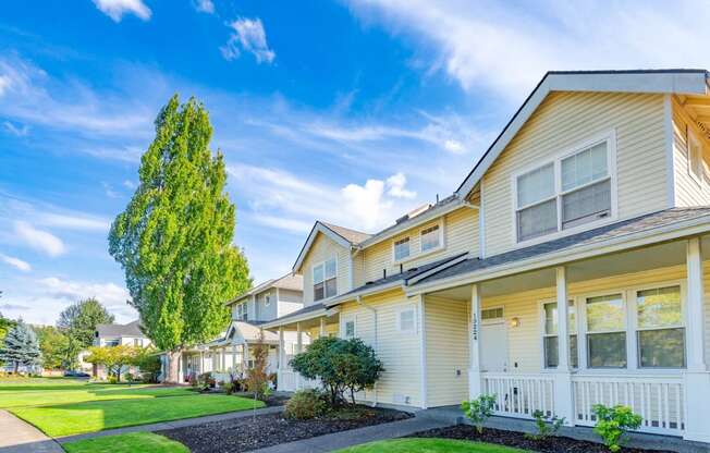 a row of houses with grass and trees in front of them