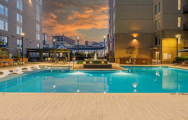 a swimming pool at a hotel with a sunset in the background