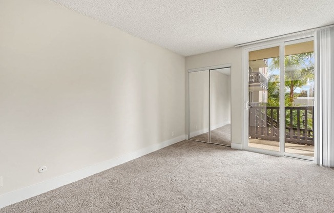 One Bedroom Apartments in Culver City CA - Parkway Plaza - Bedroom with Plush Carpeting, a Ceiling Fan, and a Closet with Mirrored Doors