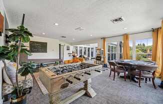 A room with a pool table and a chalkboard on the wall.
