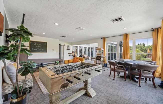 A room with a pool table and a chalkboard on the wall.