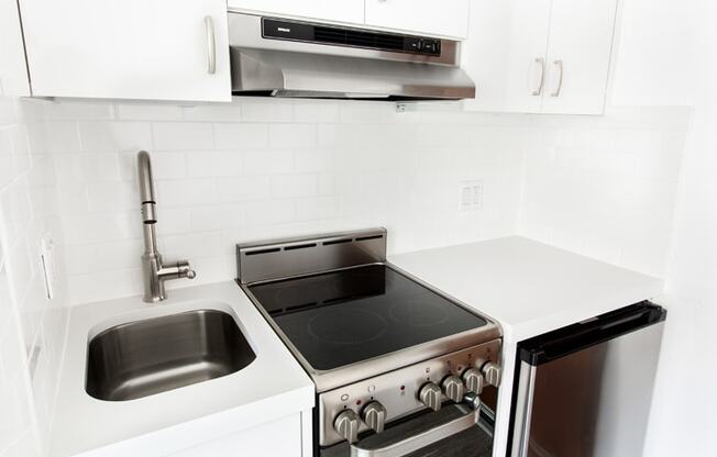 a kitchen with a stove top oven next to a sink