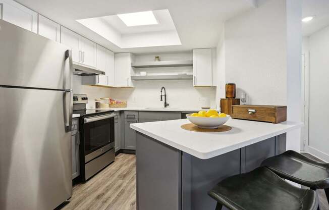 A modern kitchen with a refrigerator, oven, and sink.