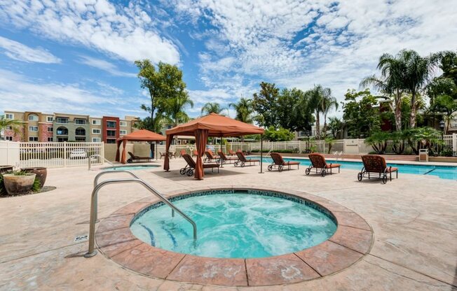 Luxury Apartments for Rent in Woodland Hills CA - Exterior Image of The Reserve at Warner Center's Expansive Pool with Chaise Chairs and Cabanas during Daytime