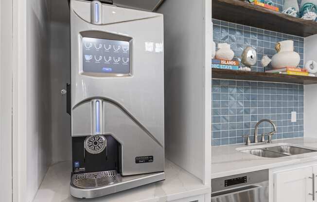 a small kitchen with a coffee machine and a sink