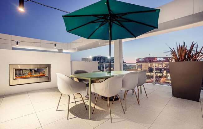 a terrace with a table and chairs and a fireplace