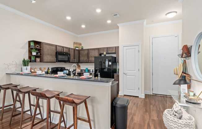 a kitchen with a bar and a counter with stools