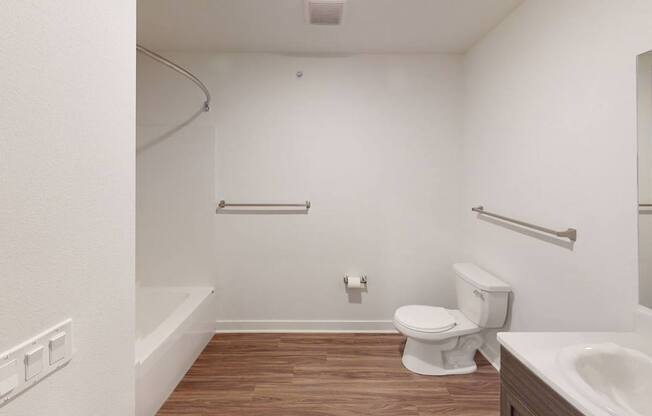 A bathroom with a toilet, sink and bathtub at Meadowbrooke Apartment Homes in Kentwood, MI 49512