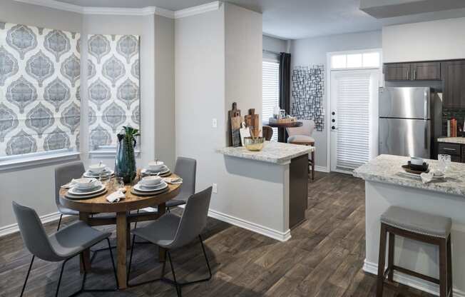 a kitchen and dining area with a table and chairs and a refrigerator