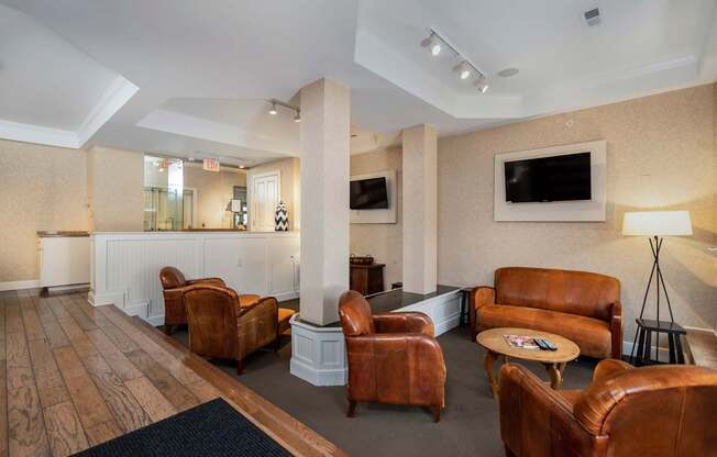 A living room with brown leather chairs and a white reception desk.
