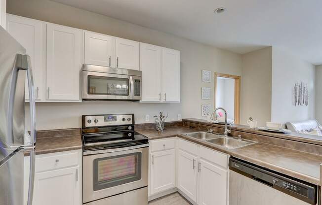 a kitchen with stainless steel appliances and white cabinets