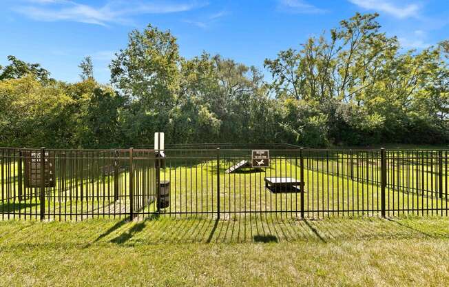 a yard with a fence and benches in the grass