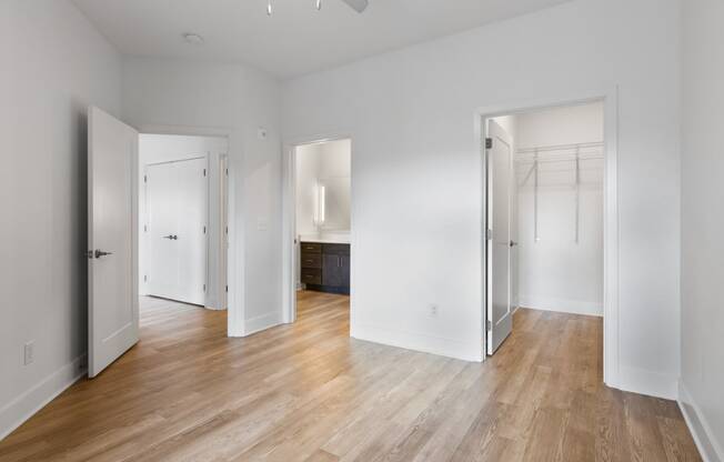 an empty living room with white walls and wood floors