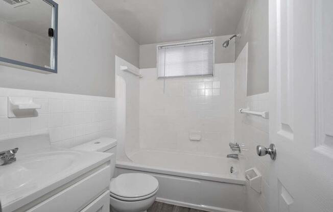 a white bathroom with a tub and a sink