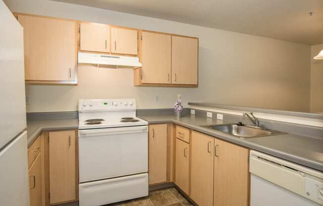 a kitchen with white appliances and wooden cabinets